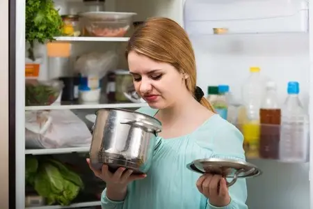 woman smelling pot from refrigerator 450x300